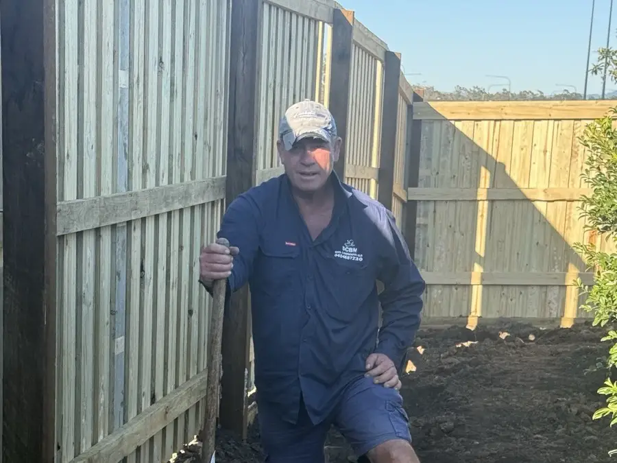 DCBM crew member on site beside a newly built fence in North Harbour, Morayfield