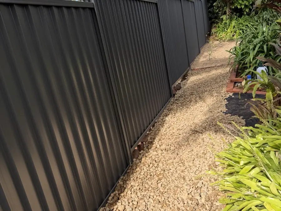 The finished gravel drainage strip along the same fence line