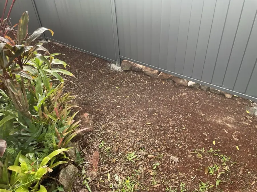Bare soil strip along a fence line before the gravel run was laid